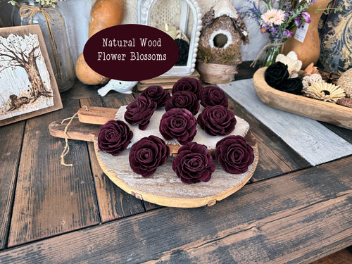 Burgundy wine wood flower blossoms laid out on a vintage bread board on an old wood table.