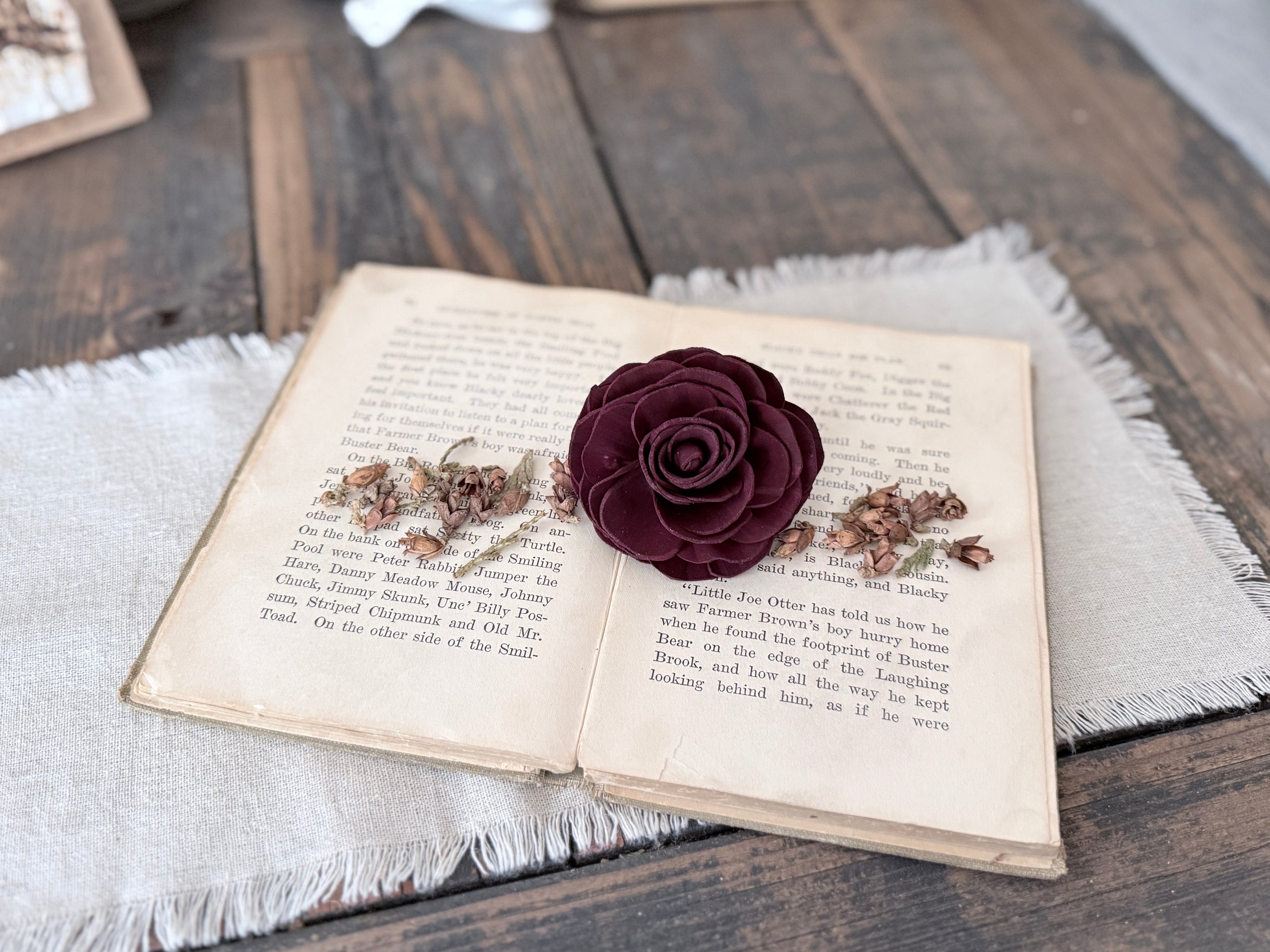 A wood flower blossom laid out on open book pages. 