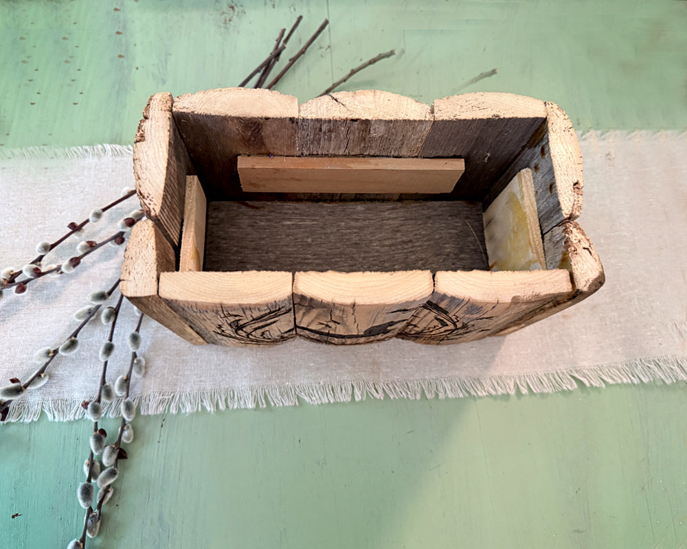 Top down view of Wooden box with a rustic design on a light green background