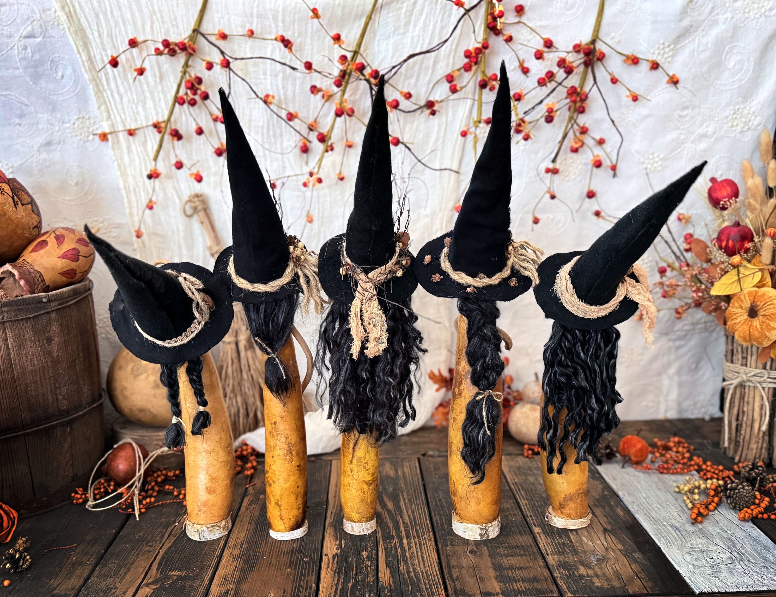 This shows the back view of five witches with black hats. Each witch has long black hair in a different style. 