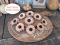 Hand-painted wooden daisies on a wooden board with decorative elements.
