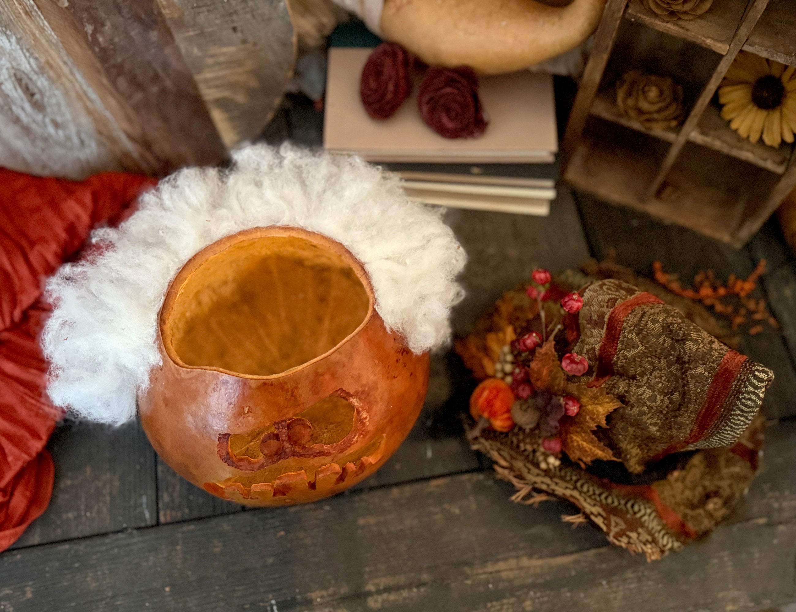 Decorative items including a gourd, white fur, and a small decorative box on a wooden surface.