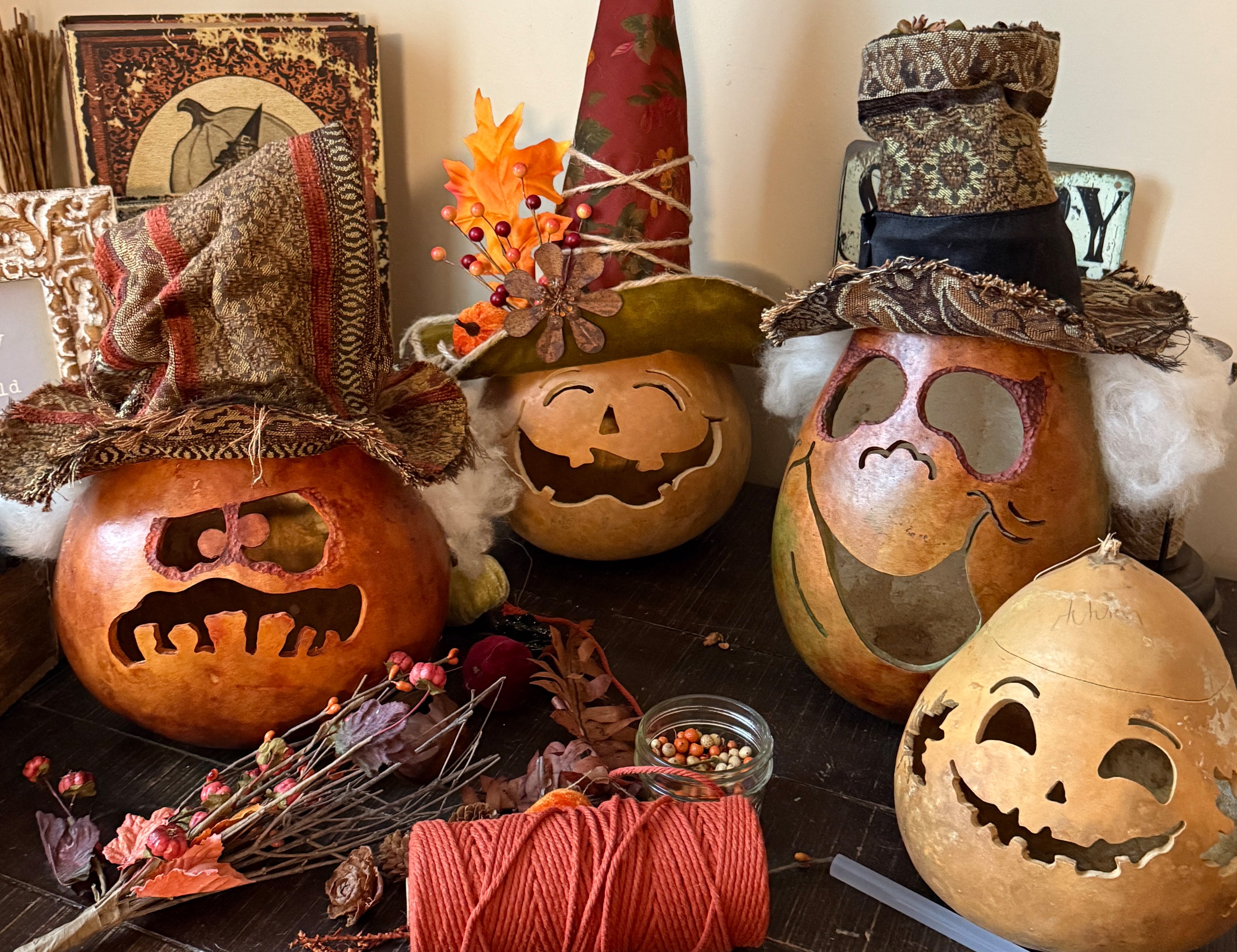 Decorative pumpkins with carved faces and autumn-themed decorations on a table.