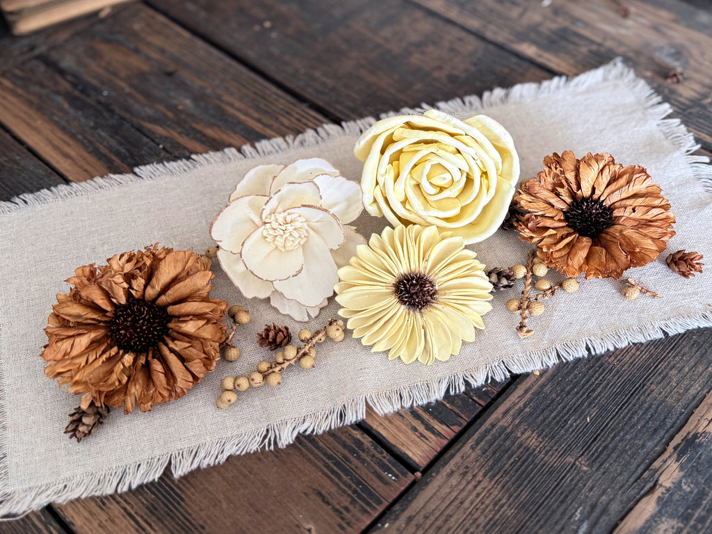 Decorative flowers on a textured fabric strip on a wooden surface