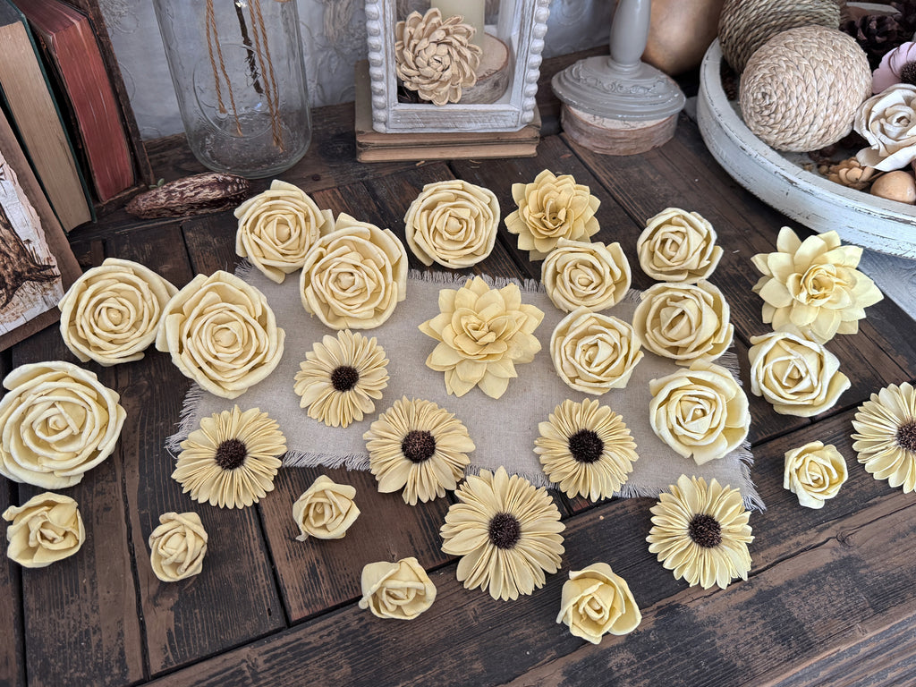 Collection of decorative yellow flowers on a wooden surface