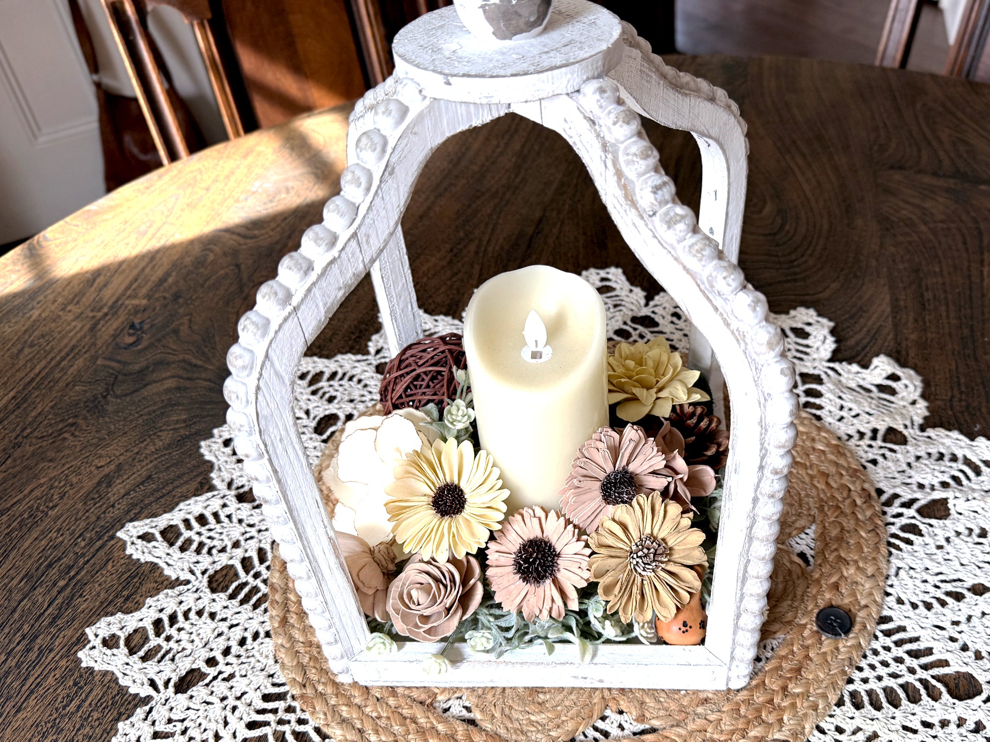 Decorative white lantern with a candle and flowers on a lace tablecloth