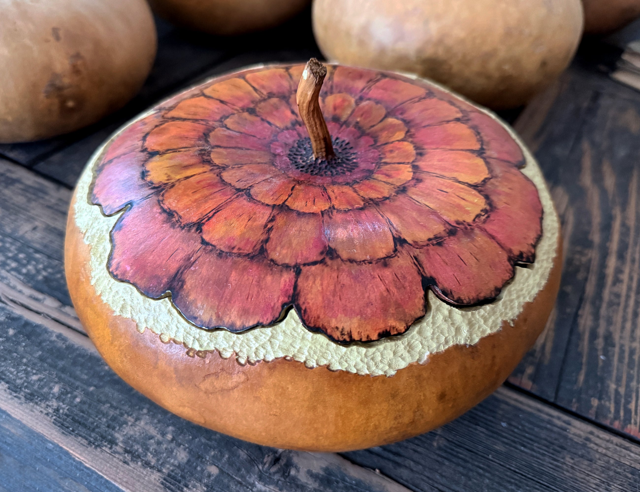 Close-up of hand-painted zinnia bloom with layered petals on gourd bowl lid