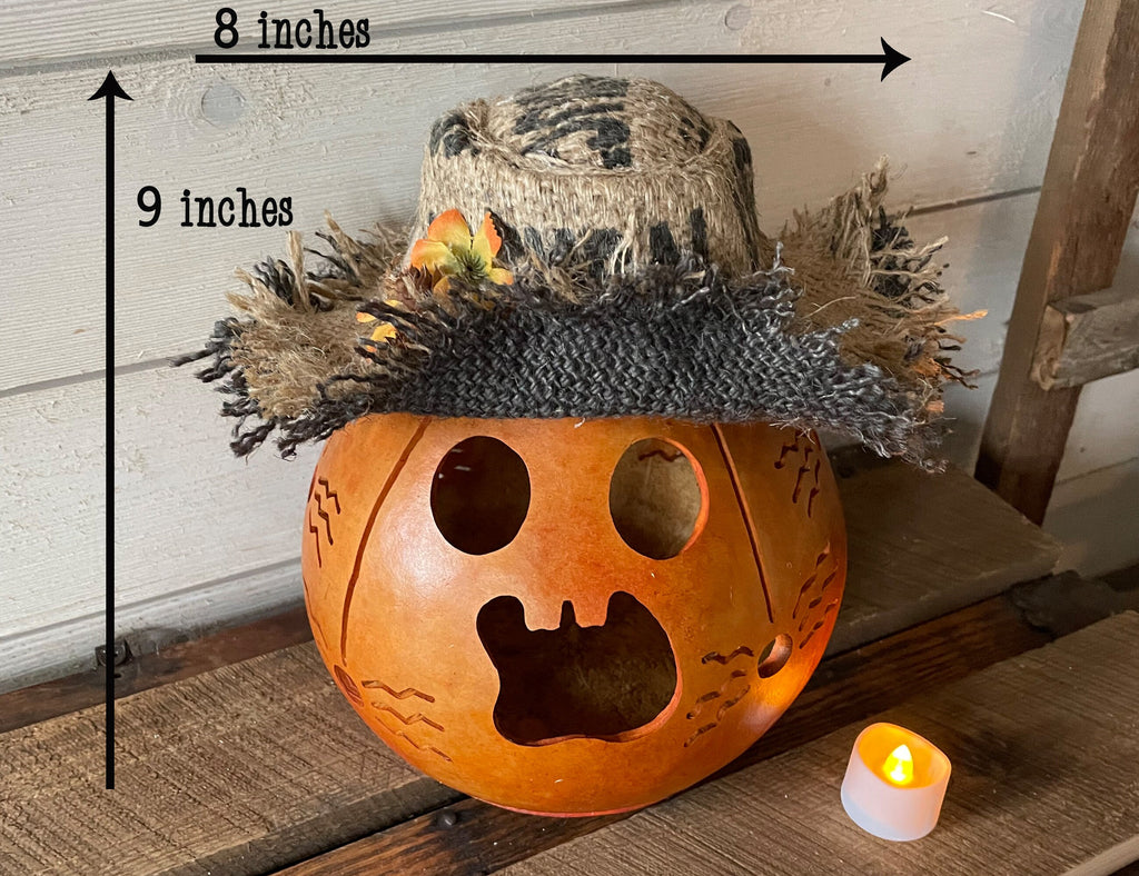Pumpkin with a top hat and measurements on a wooden surface