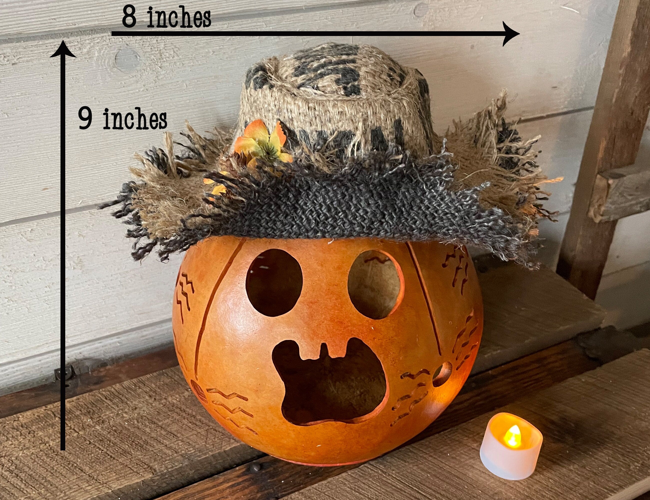 Pumpkin with a top hat and measurements on a wooden surface