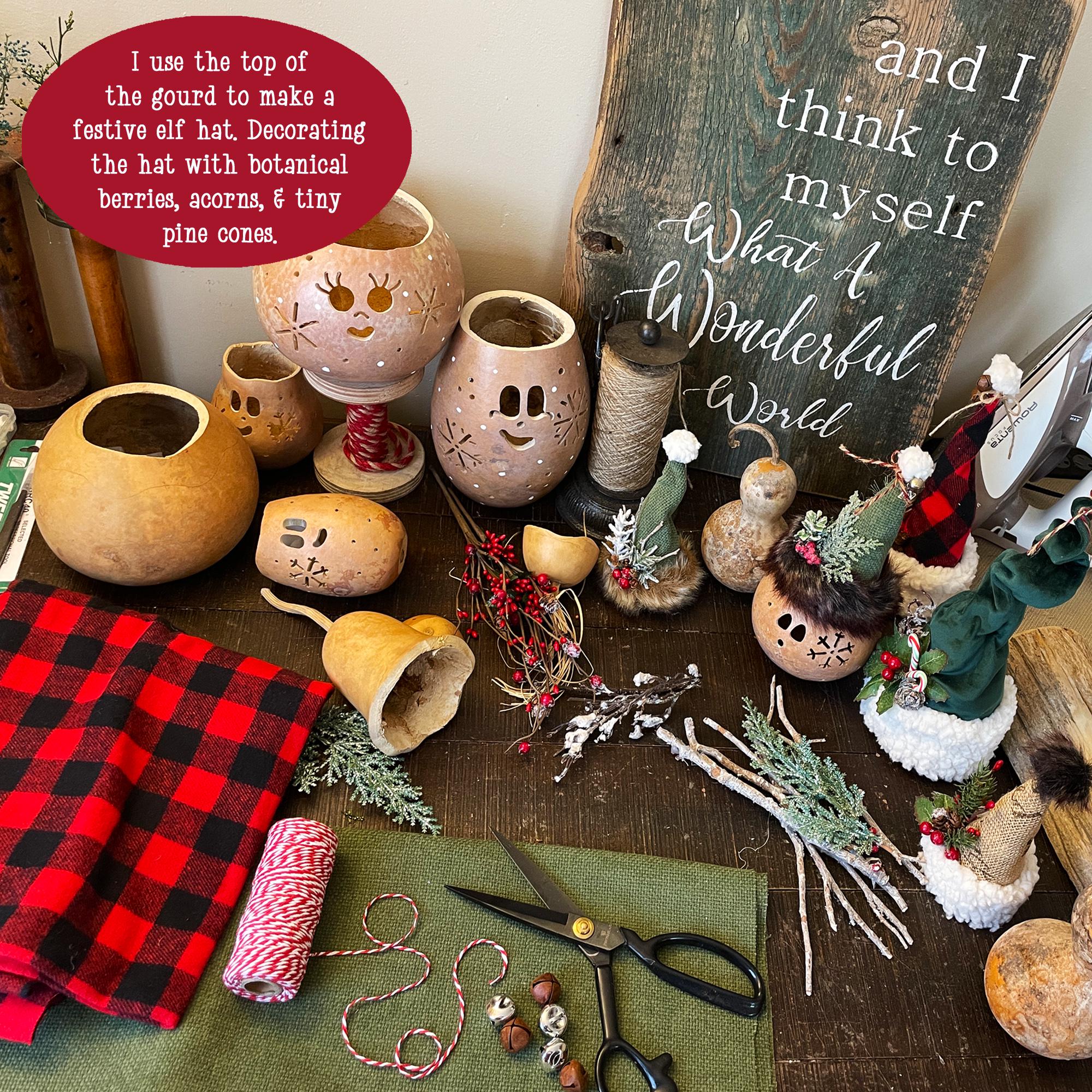 Decorative gourds with face designs on a table with craft supplies and a chalkboard sign.