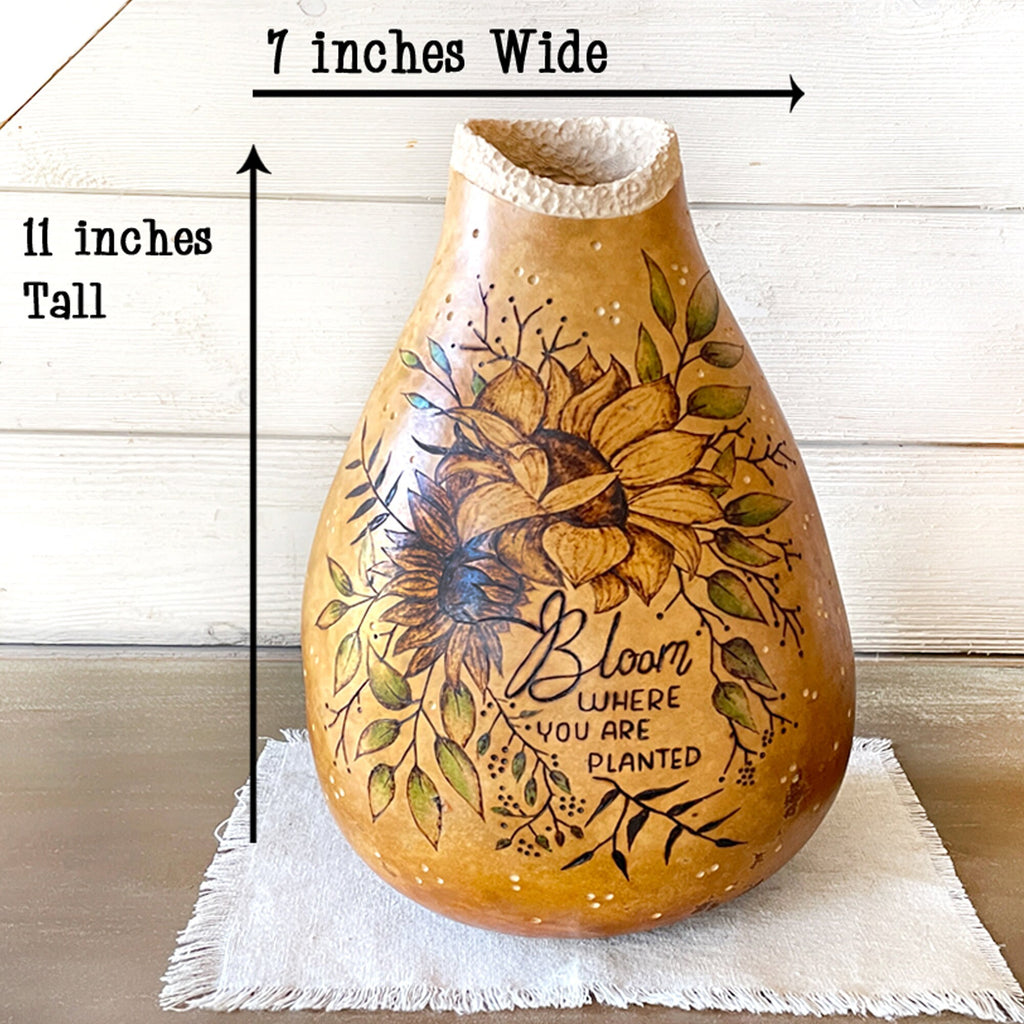 Decorative gourd vase with floral design and text, shown with measurements on a wooden surface.