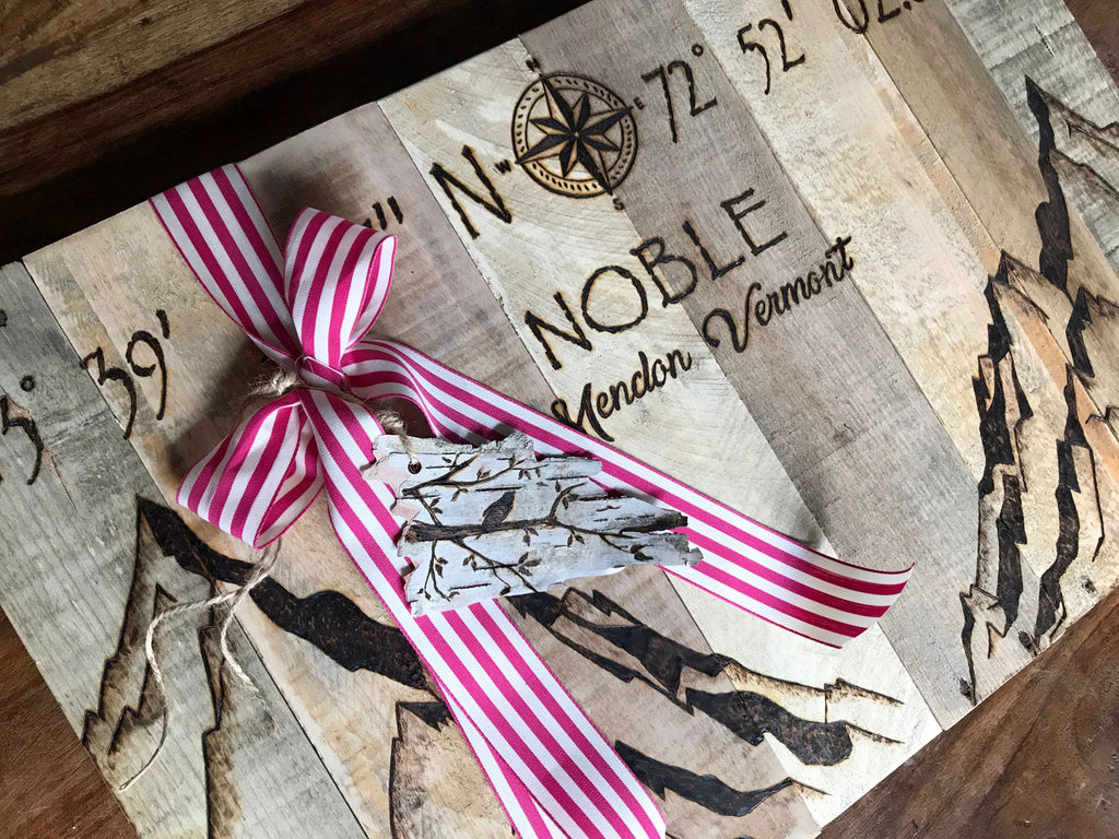 Decorative item with a pink and white striped ribbon on a wooden surface with text and graphics.