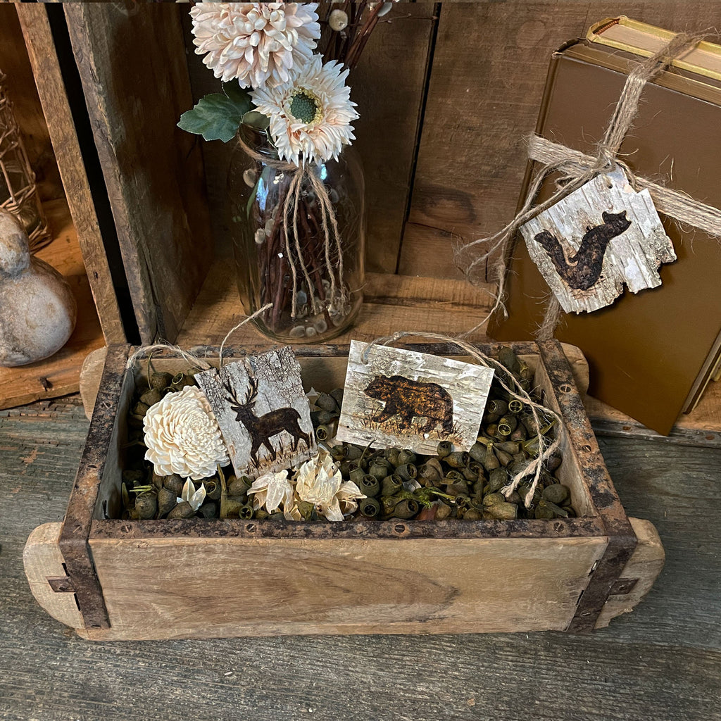 Decorative wooden box with nature-themed decorations on a rustic wooden surface
