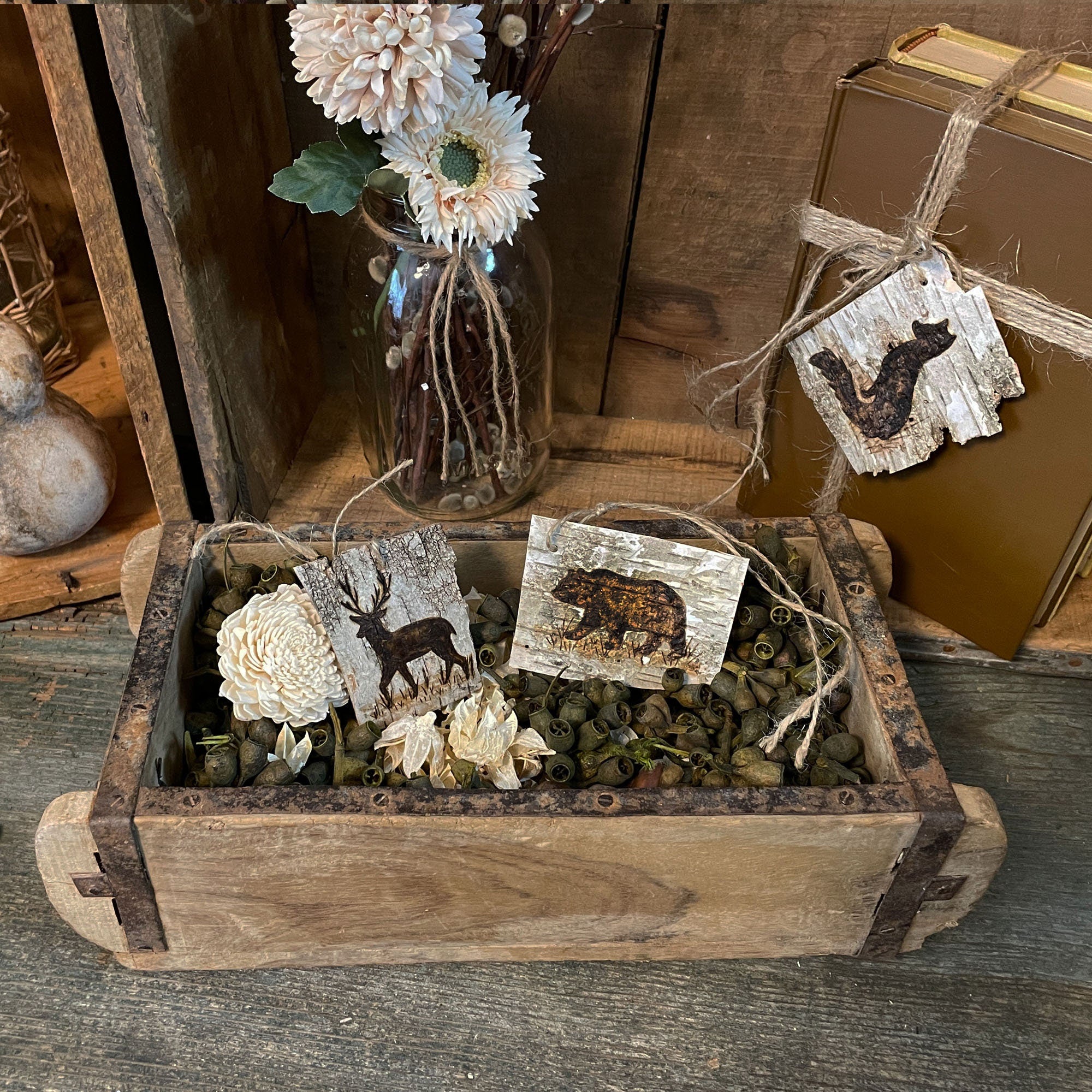 Decorative wooden box with nature-themed decorations on a rustic wooden surface
