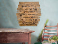 Wooden wall art with a inspirational quote on a light blue wall, with a rustic wooden table and chair in the foreground.