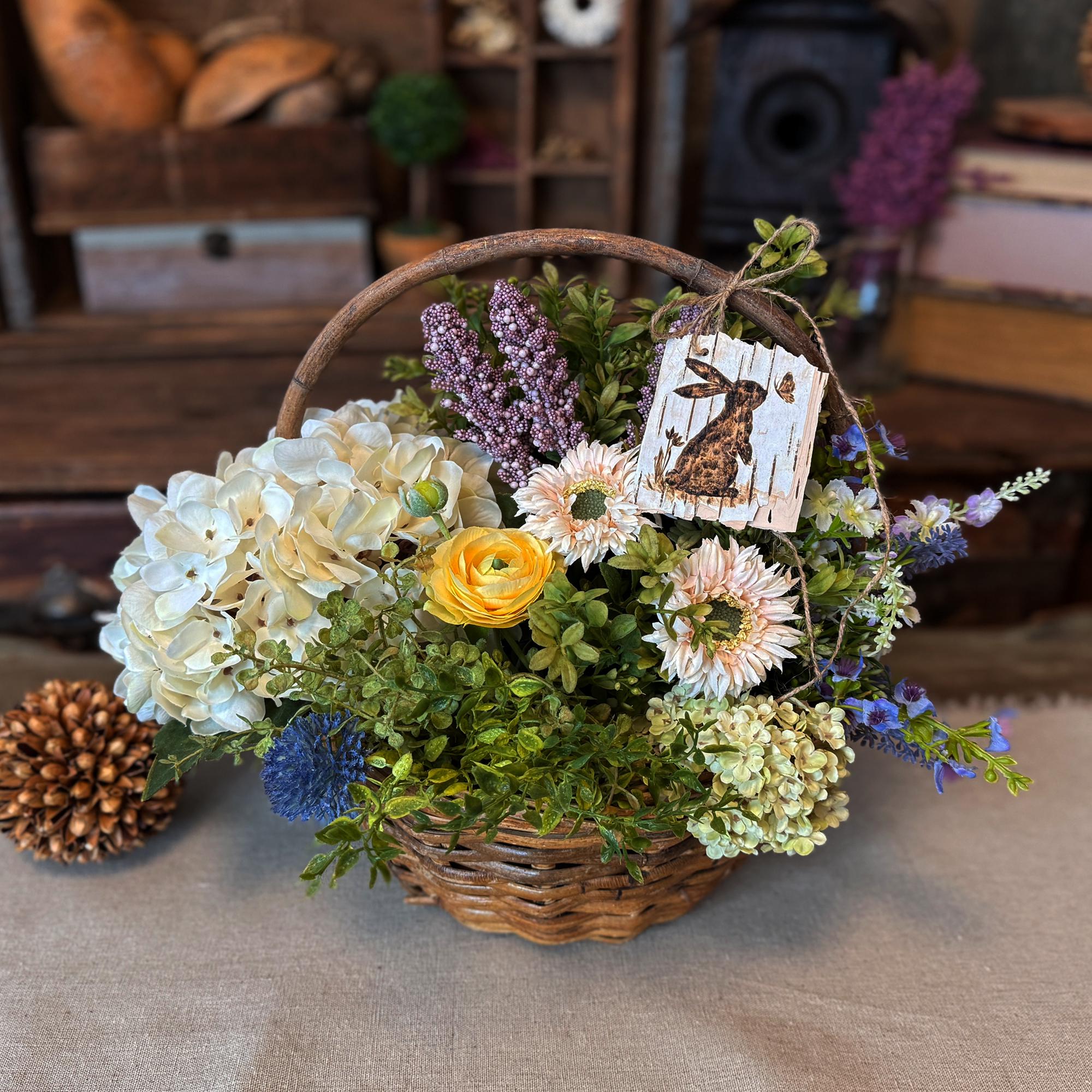 Wicker basket filled with a variety of flowers on a textured surface.