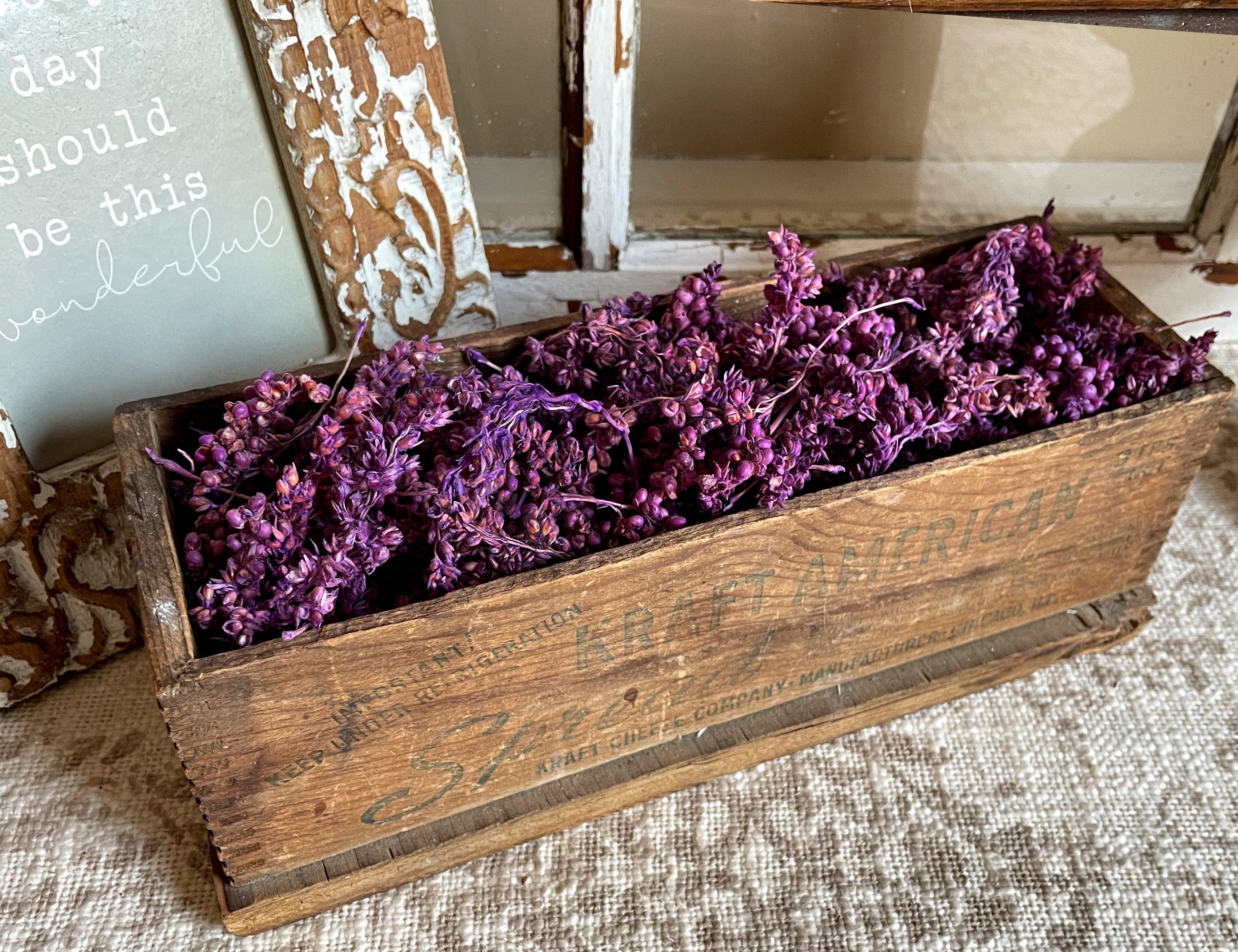 Wooden box with purple flowers on a textured surface