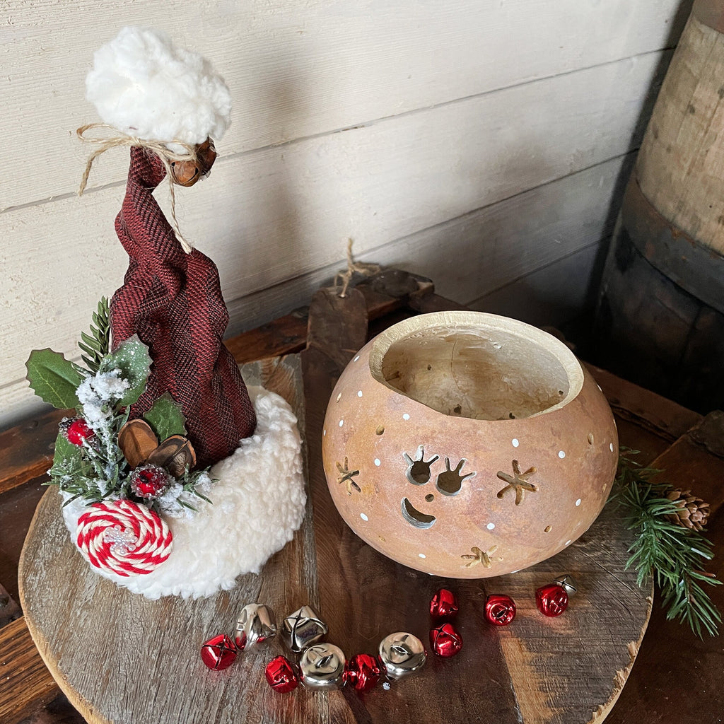Decorative lantern with Christmas-themed decorations on a wooden surface