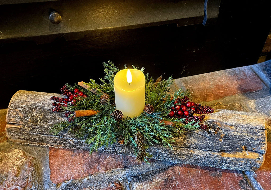 Decorative log with a candle and greenery on a rustic surface, featuring the website 'www.boutiquebarnet'.
