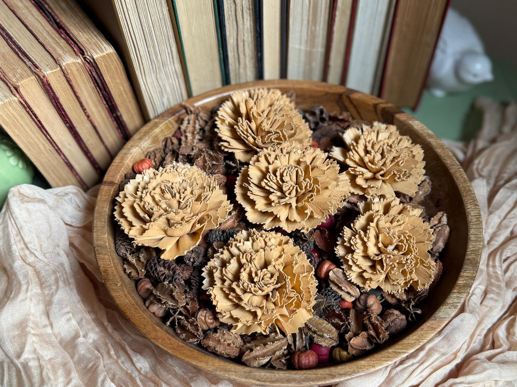 Wooden bowl with wood flowers and herbs on a textured surface