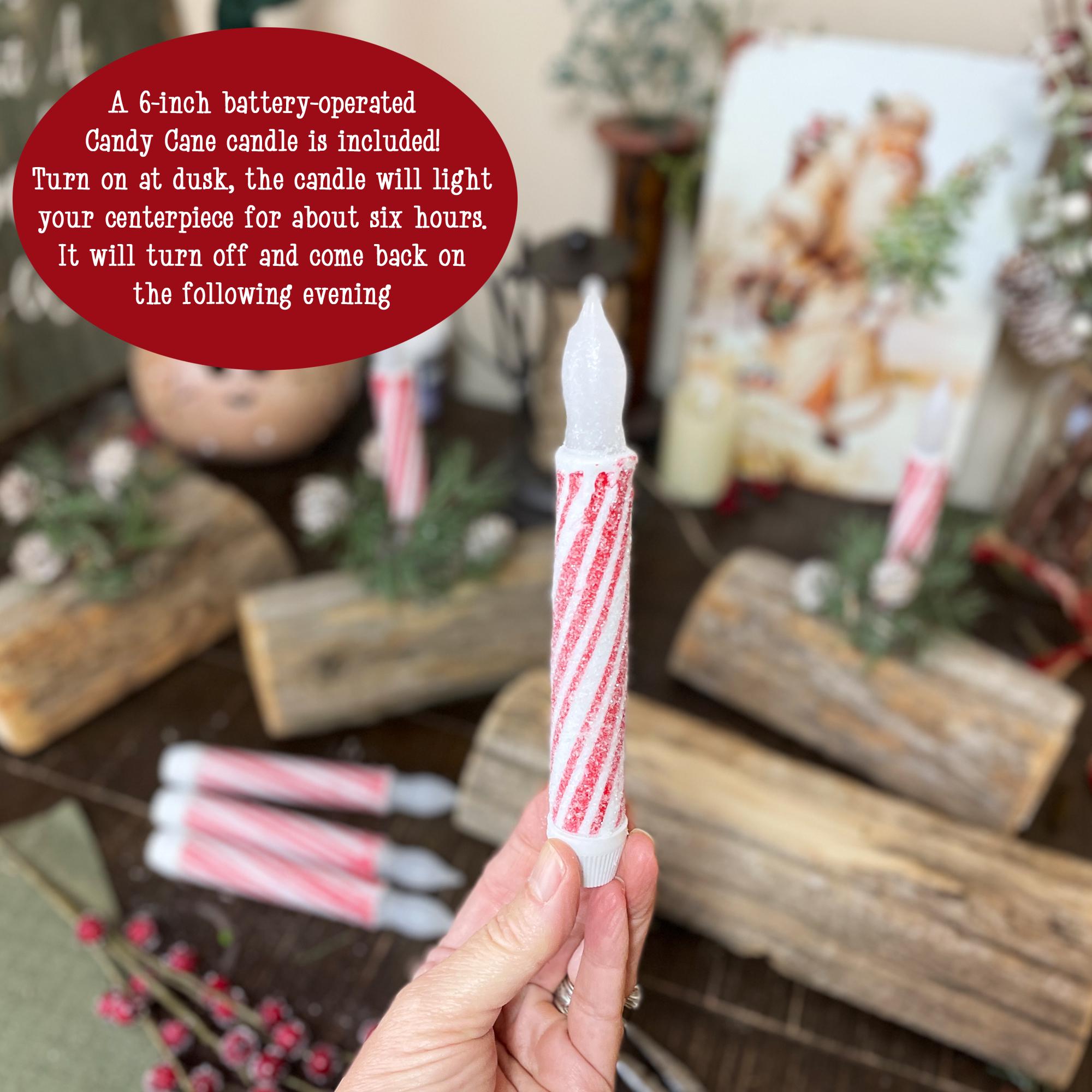 Hand holding a candy cane candle with a festive background