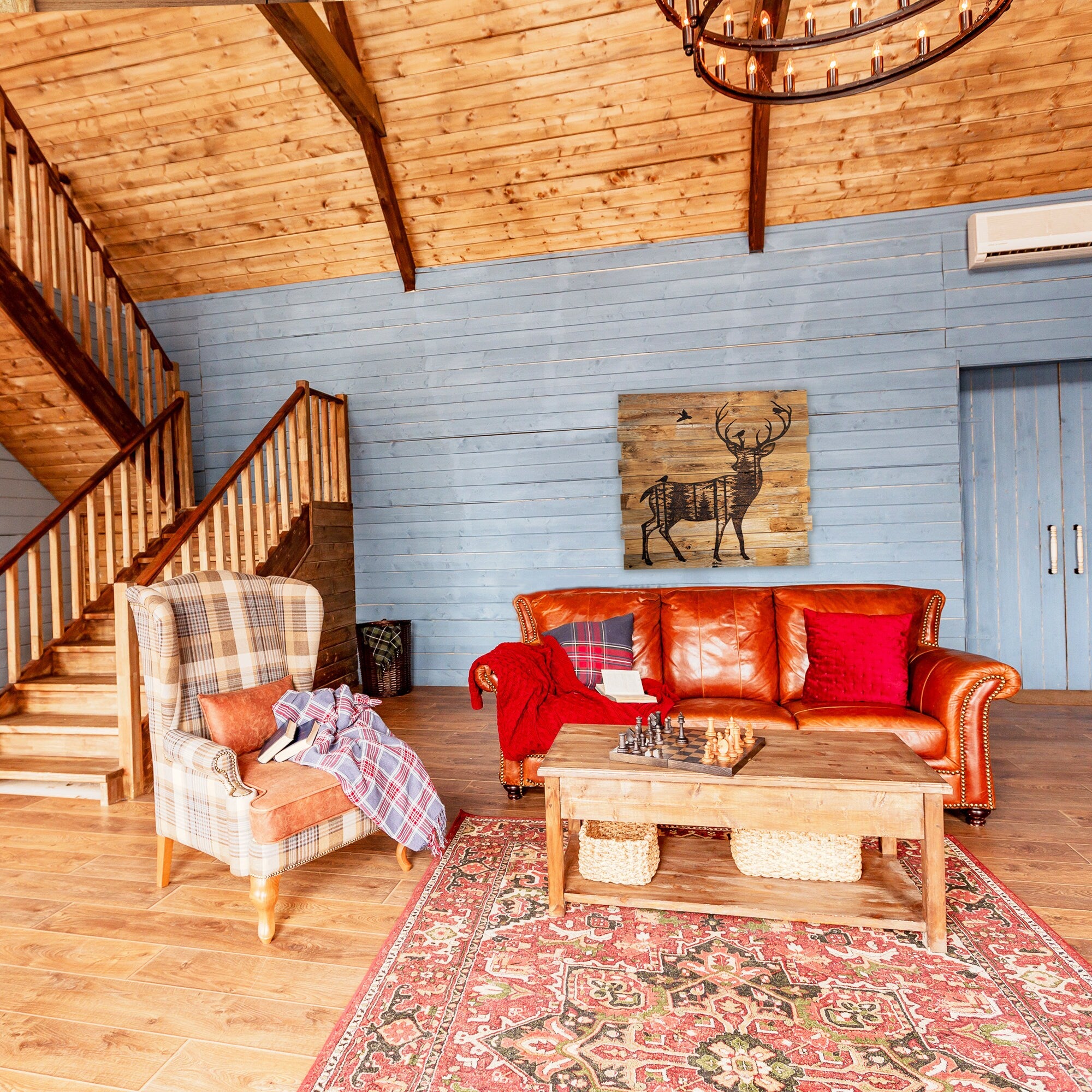 Living room with leather sofa, armchair, and wooden coffee table in a rustic setting.