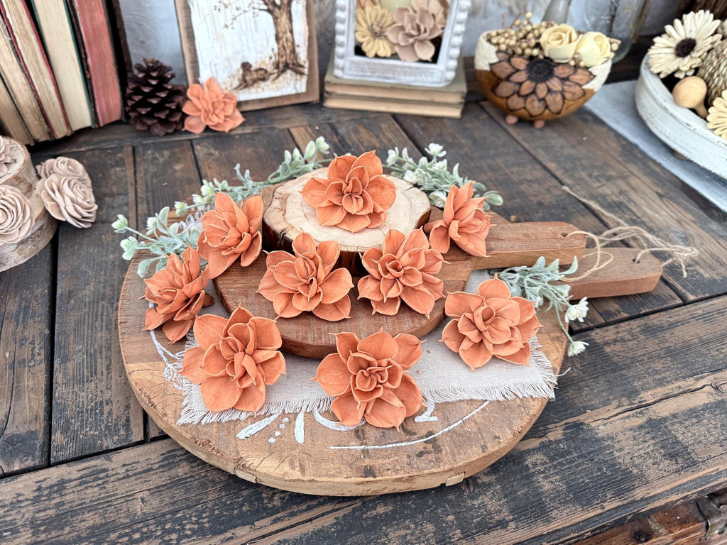 Decorative arrangement of orange wood flowers on a wooden surface with a rustic background.
