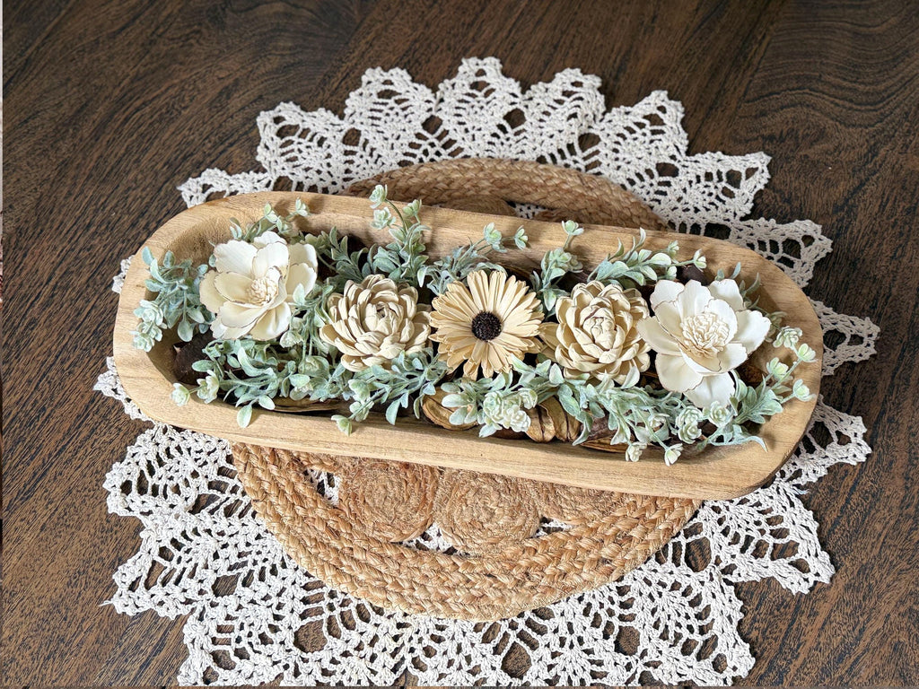 Wooden dough bowl with decorative wood flower blossoms on a lace doily
