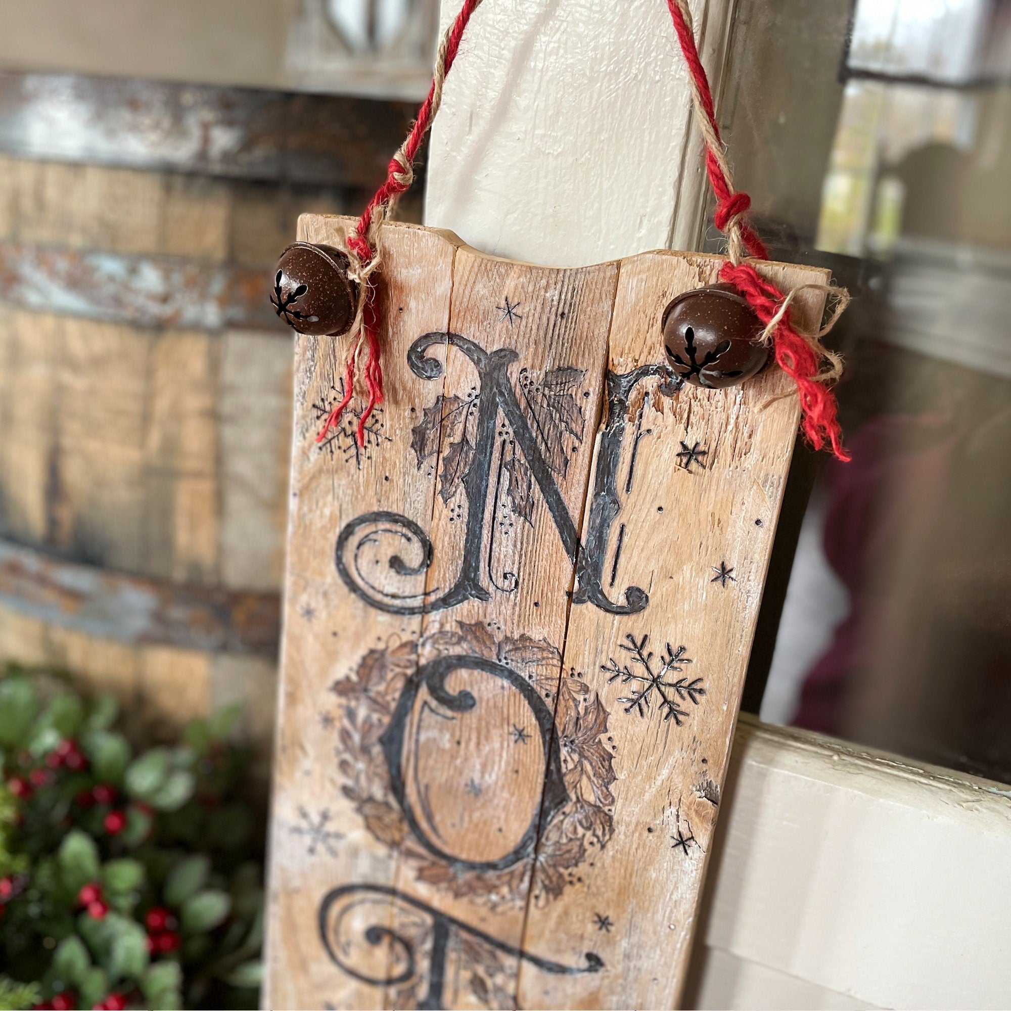 Wooden sign with 'Merry Christmas' decoration hanging indoors.