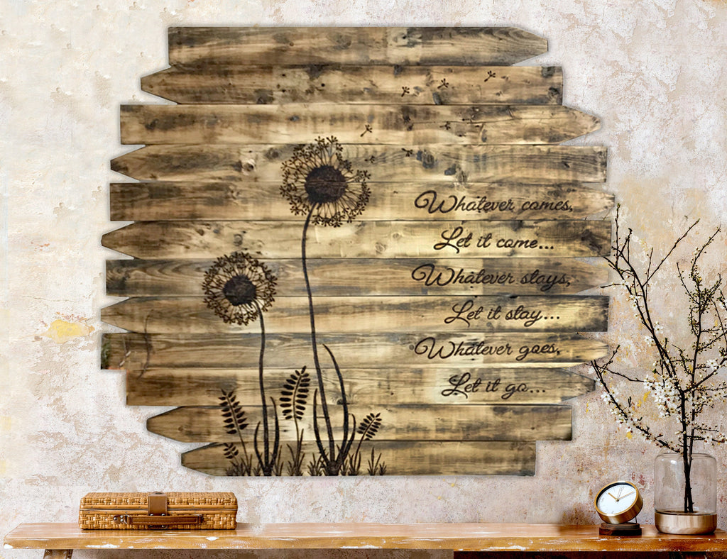 Wooden wall art with dandelion designs and motivational text on a textured wall.