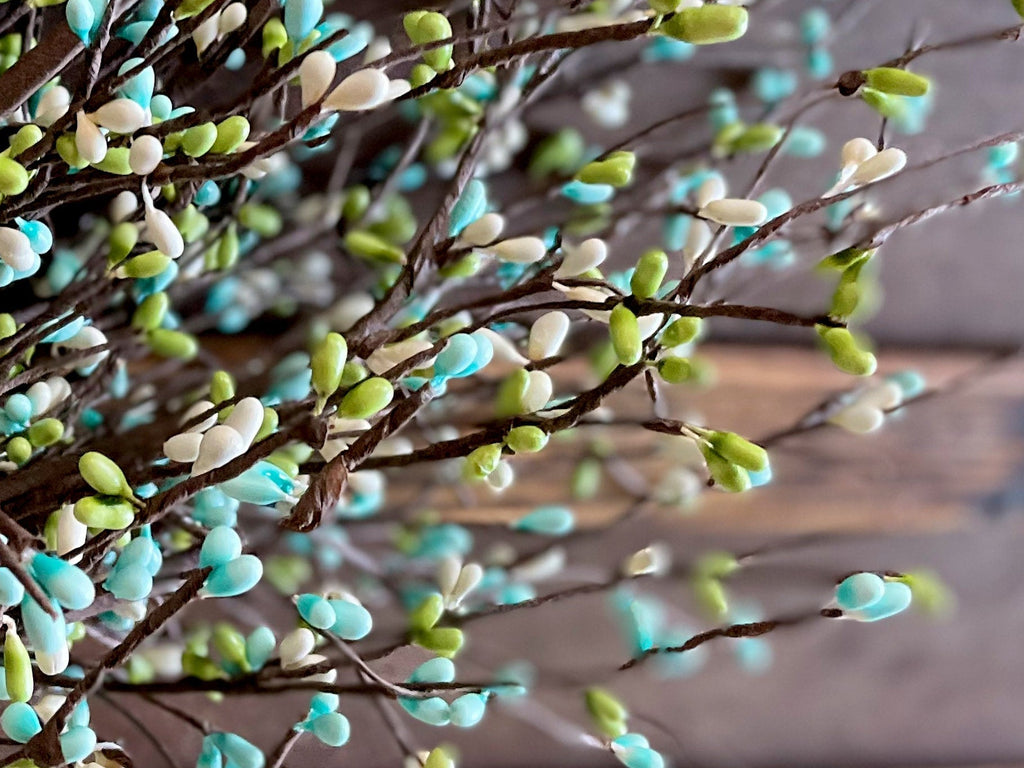 Decorative branch with green and blue buds on a wooden surface, featuring Etsy branding.