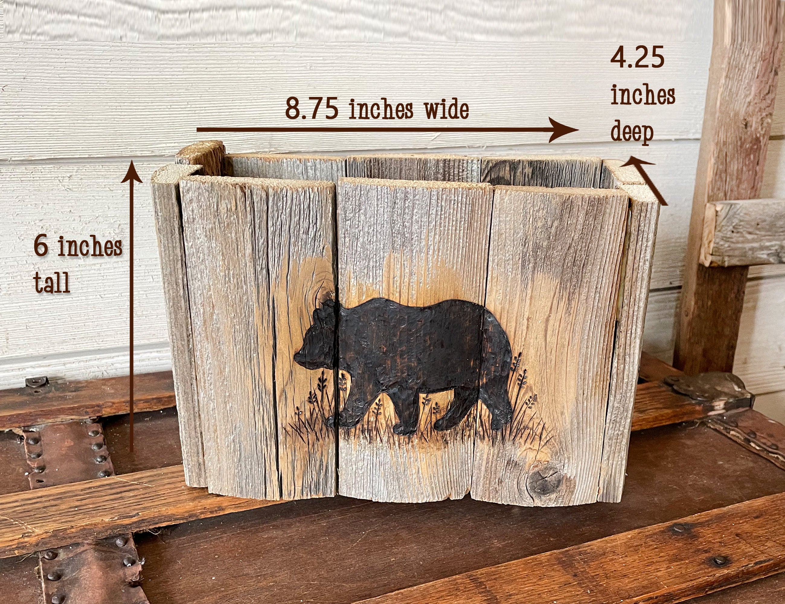 Wooden planter with bear design and measurements on a rustic wooden surface.