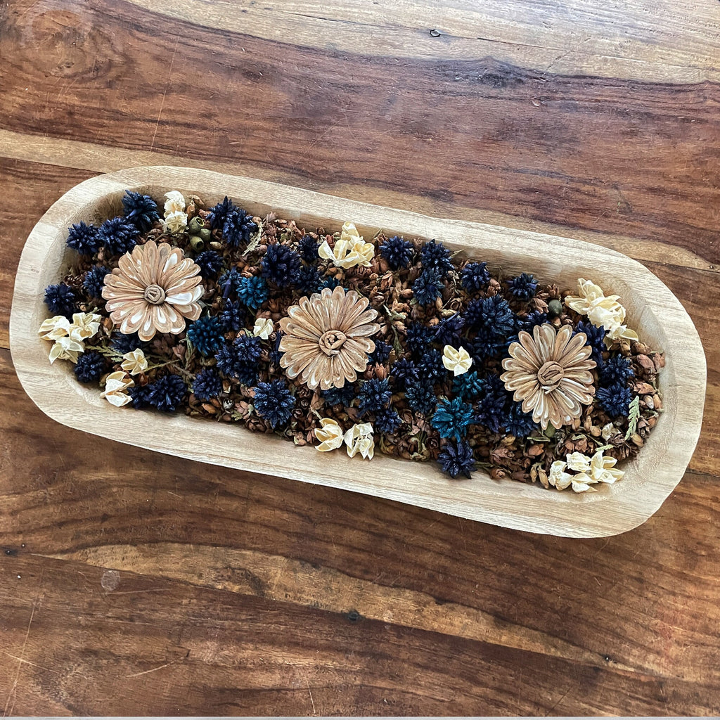Wooden tray with dried flowers on a wooden surface