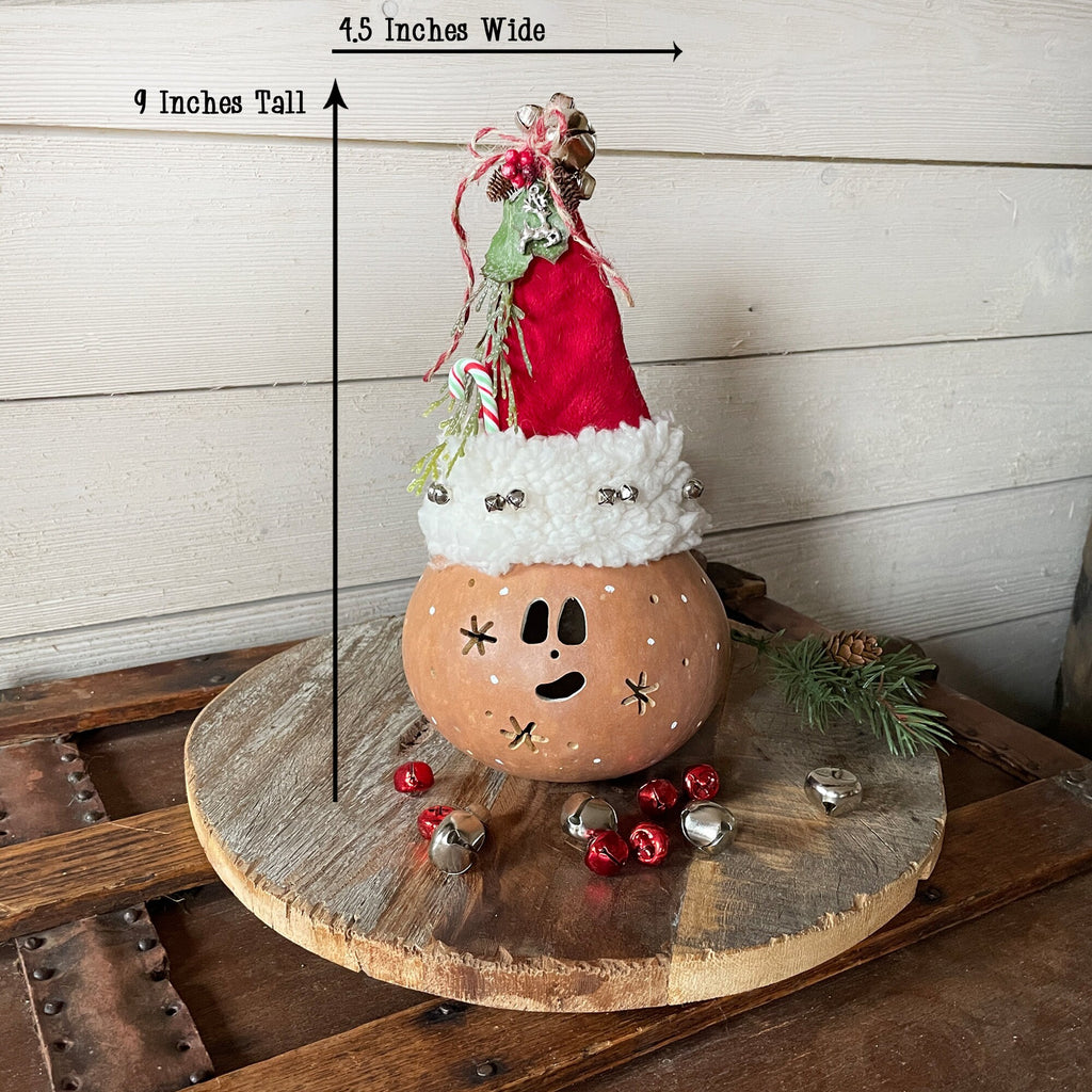 Decorative pumpkin with a Santa hat on a wooden surface, with measurements indicated.