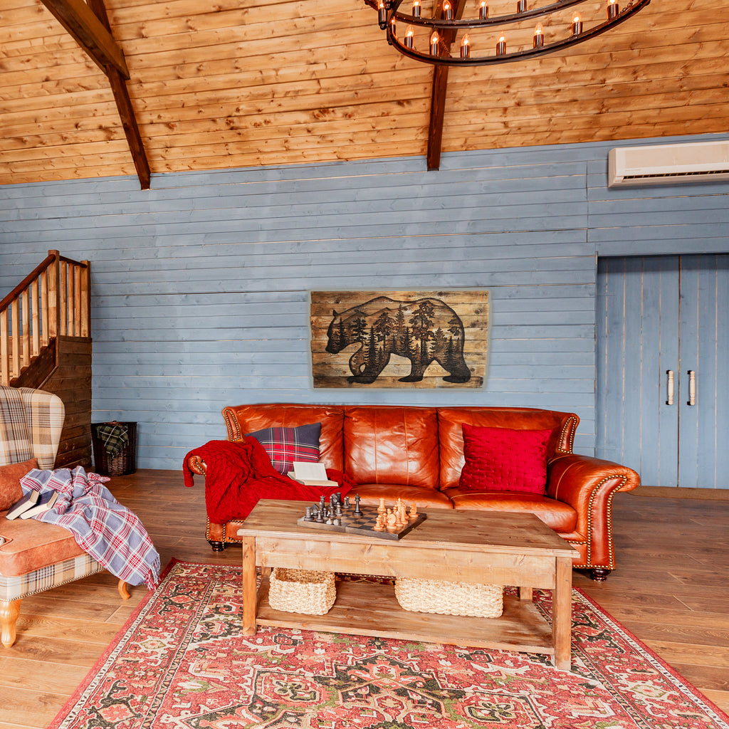 Living room with leather sofa, wooden coffee table, and bear artwork on blue paneled wall.