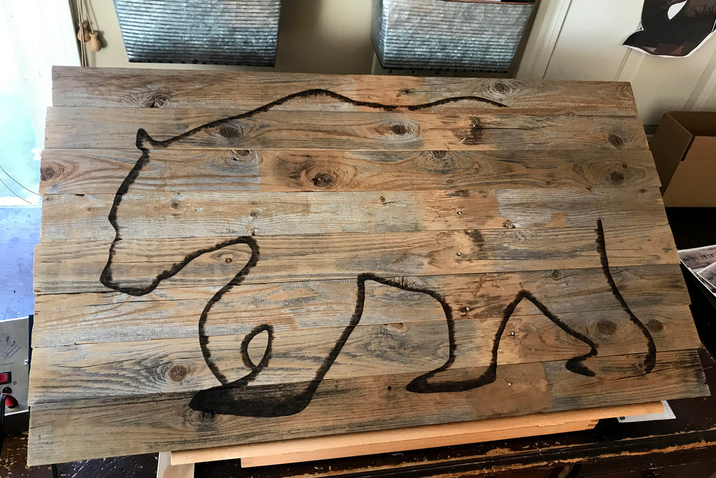 Wooden board with abstract black line art on a blurred indoor background