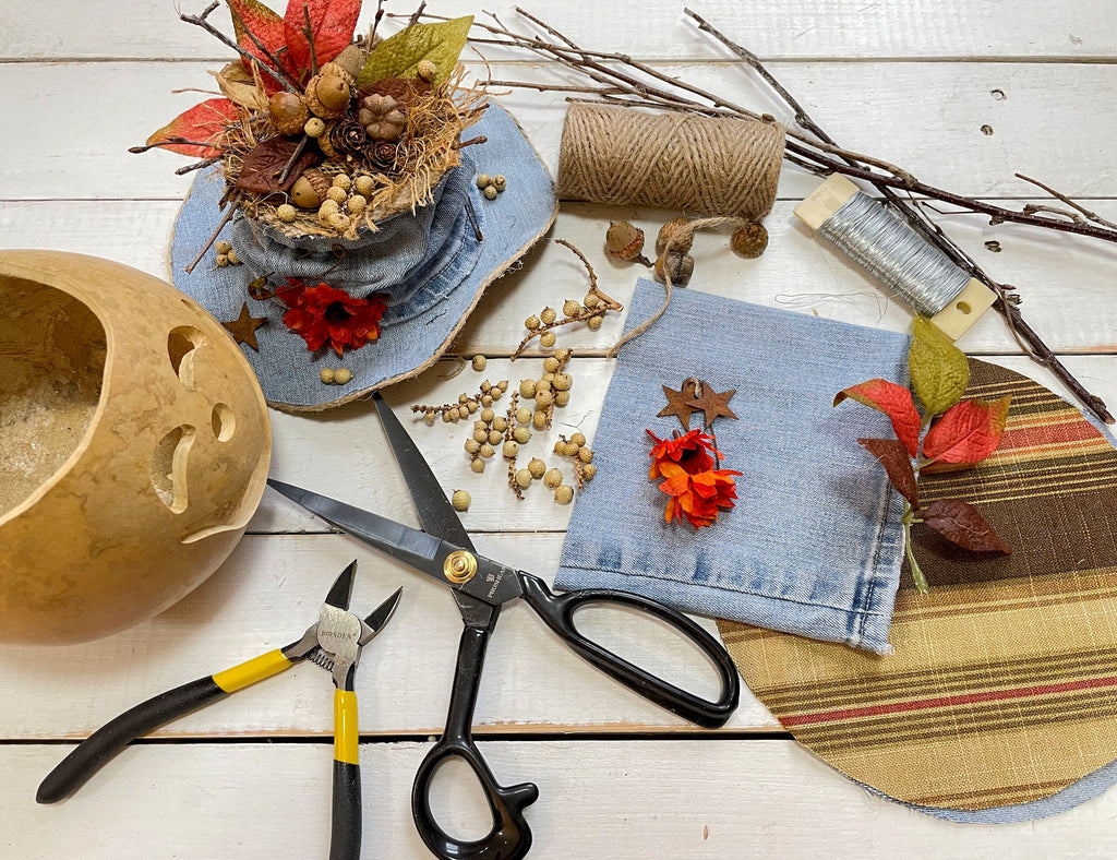 Crafting materials including scissors, pliers, fabric, and decorative elements on a wooden surface.