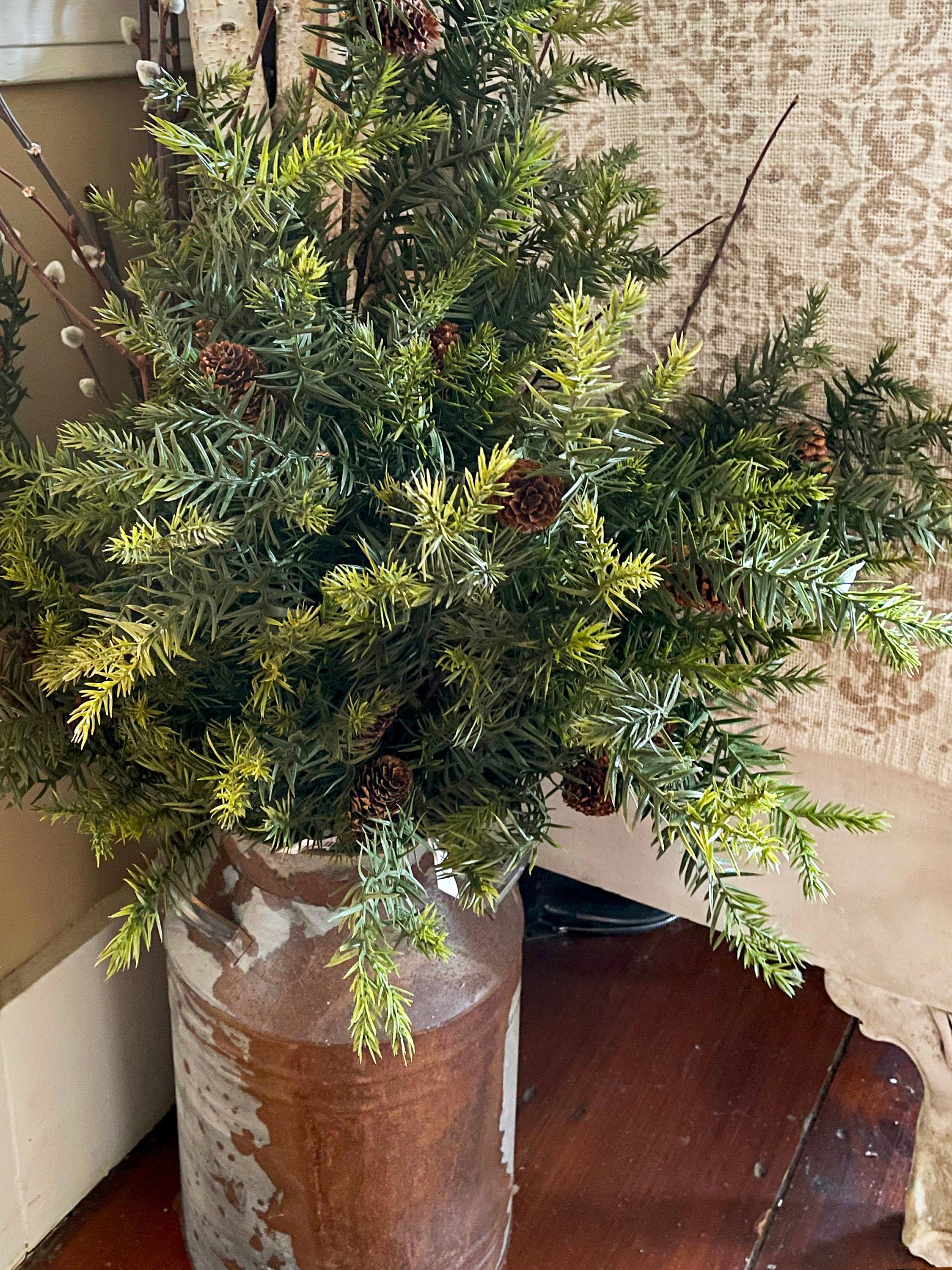 old milk can with greenery arrangement