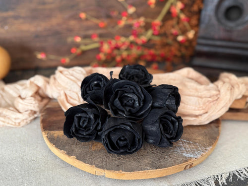 Black wood roses on a wooden board with a textured background
