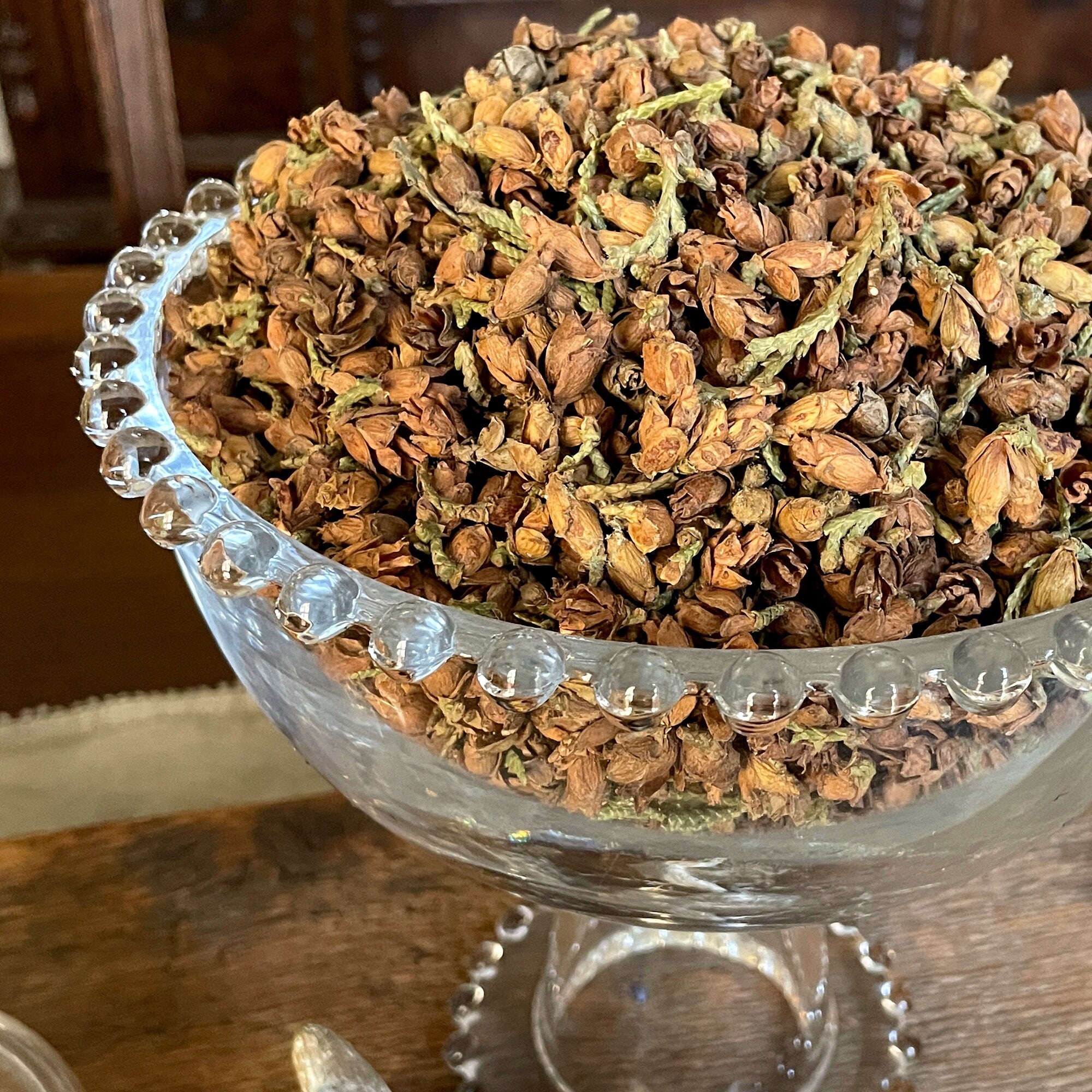 Dried herbs in a glass bowl on a wooden surface