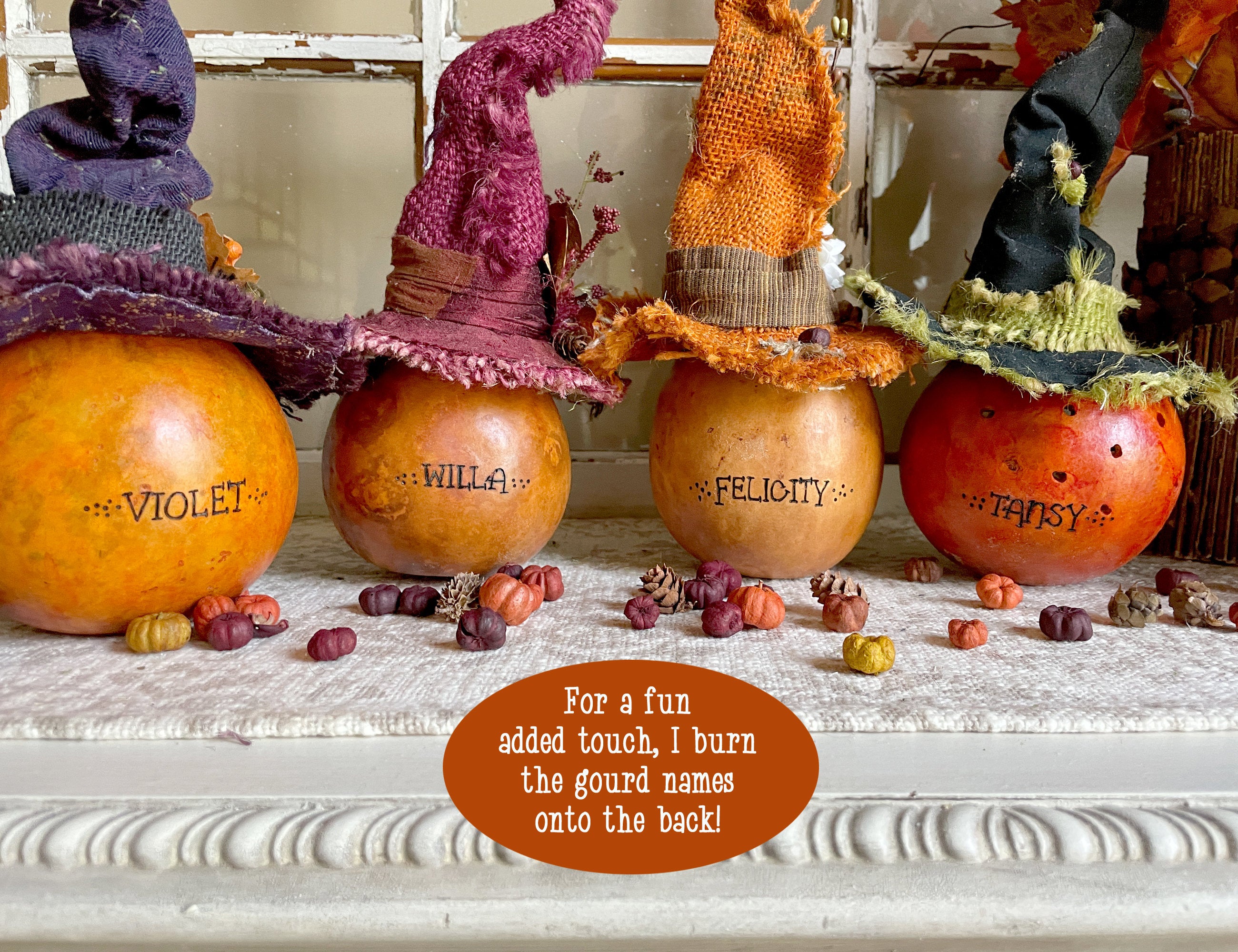 Decorative pumpkins with witch hats and names on a mantel.
