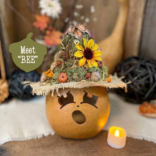 Decorative pumpkin with a small tree and sunflower on top, featuring the text 'Meet BEE'.