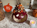 Decorative pumpkin with natural elements on a textured surface with a candle.