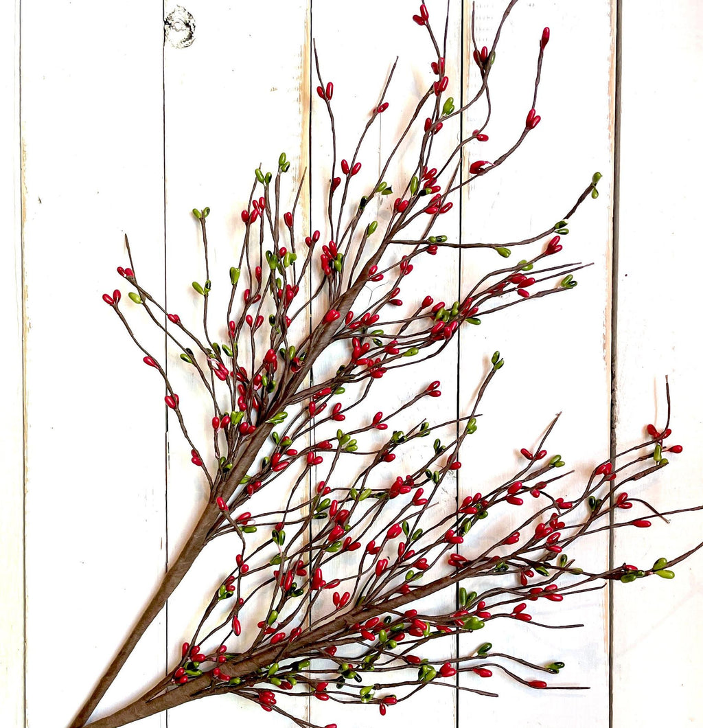 Decorative branch with red berries on a white wooden background