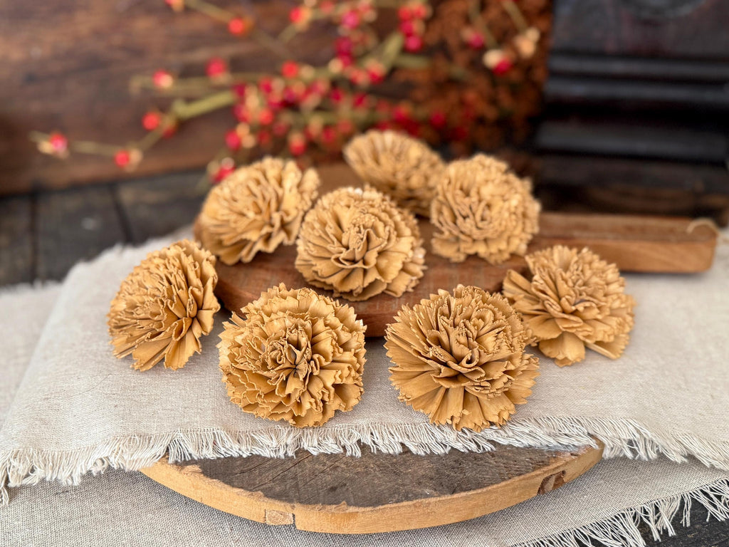 Brown wood flower carnations laid on a wooden board with a rustic background