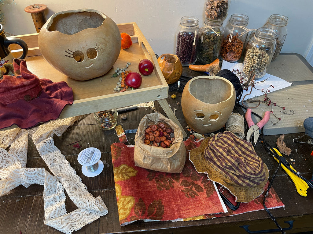 Workshop table with ceramic pots, jars, and tools on a wooden surface.