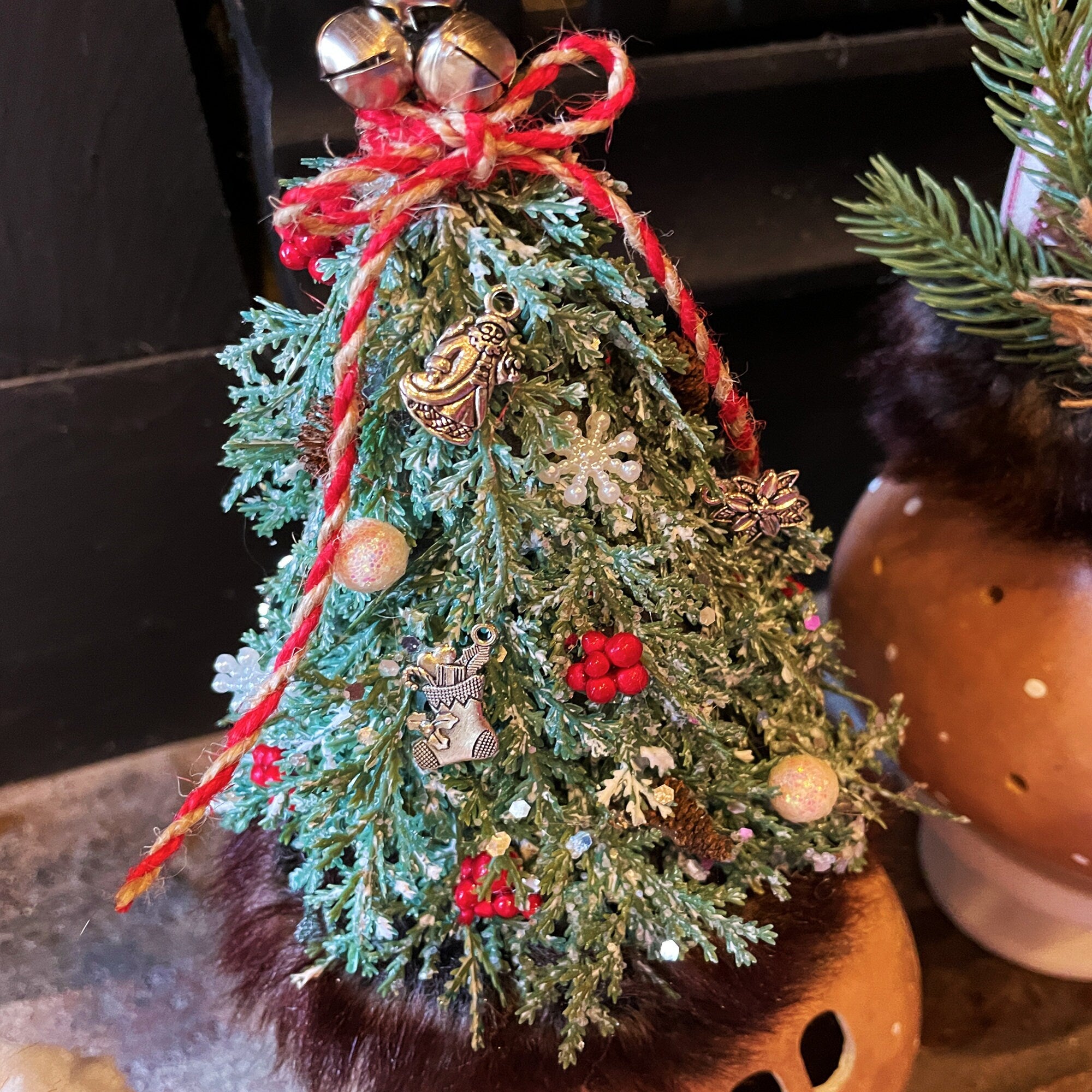 Small decorated Christmas tree with ornaments and ribbons on a dark background