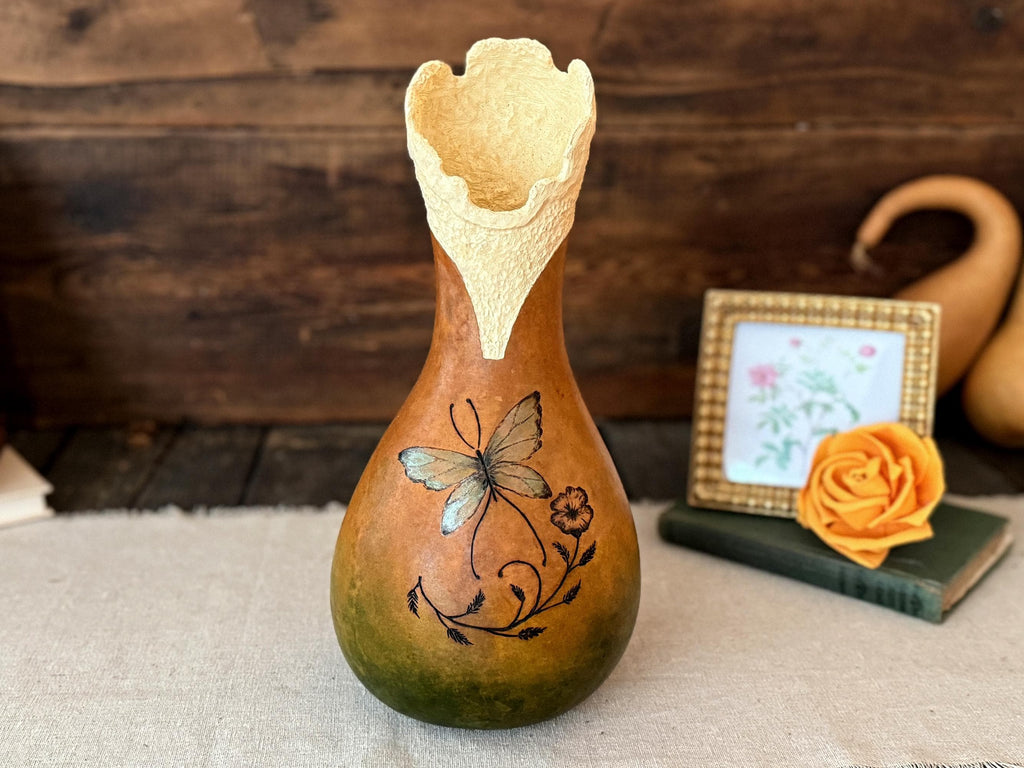 Decorative gourd with floral design on a wooden surface