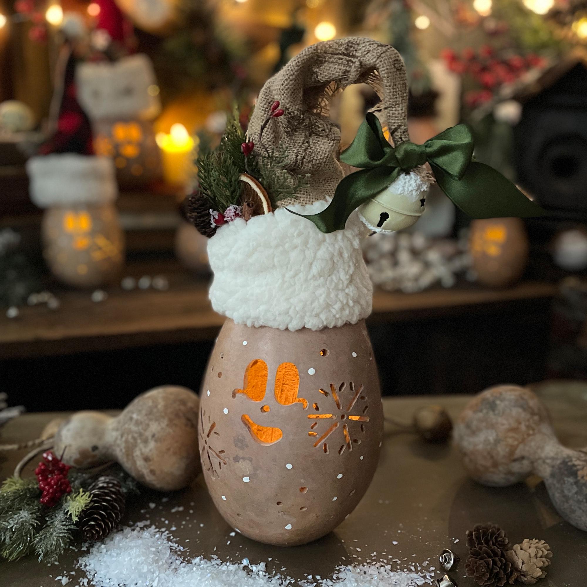 Decorative lantern with winter theme on a wooden surface with blurred festive background