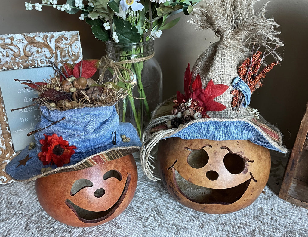 Decorative pumpkins with faces and hats on a textured surface